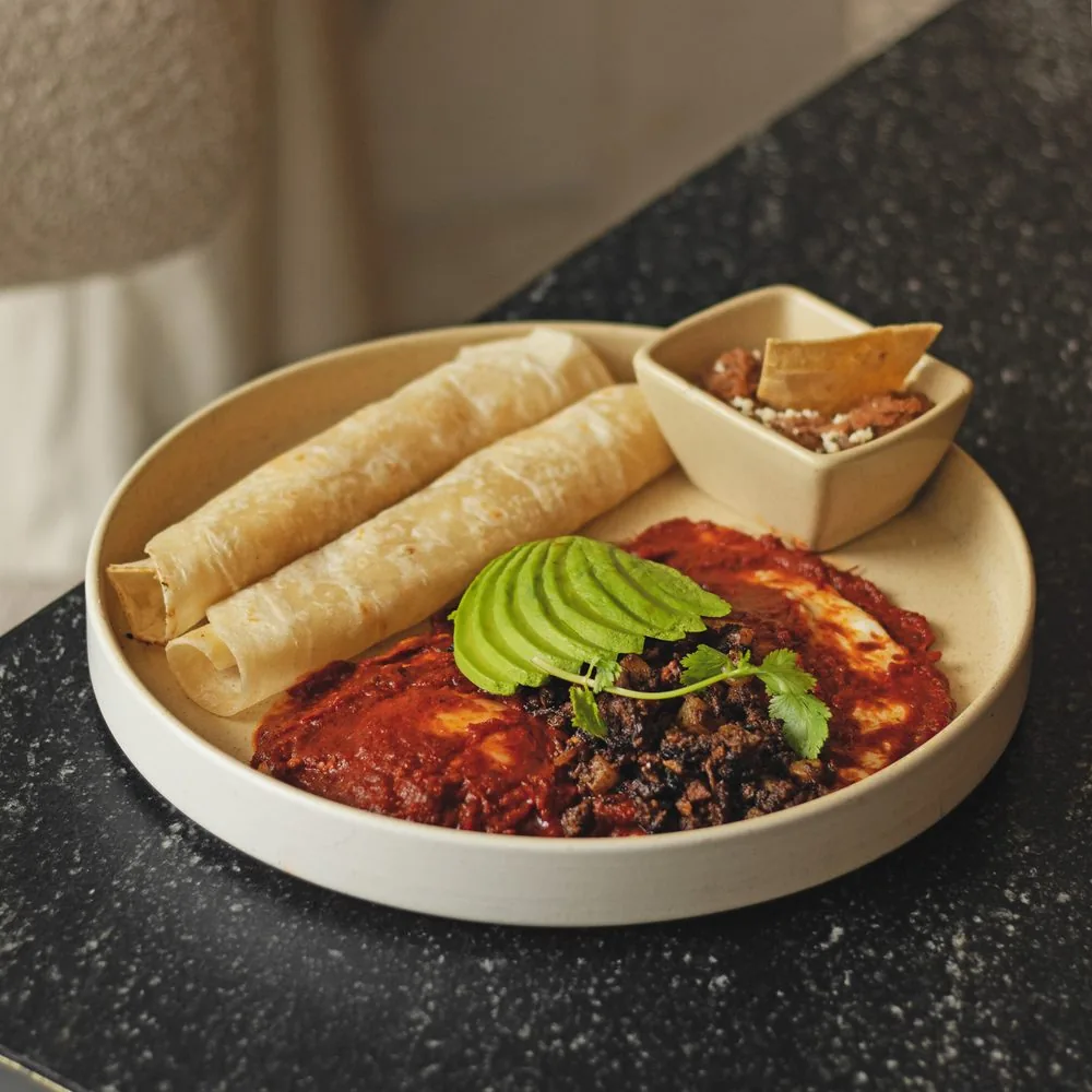 Enchiladas con aguacate sobre la mesa de granito