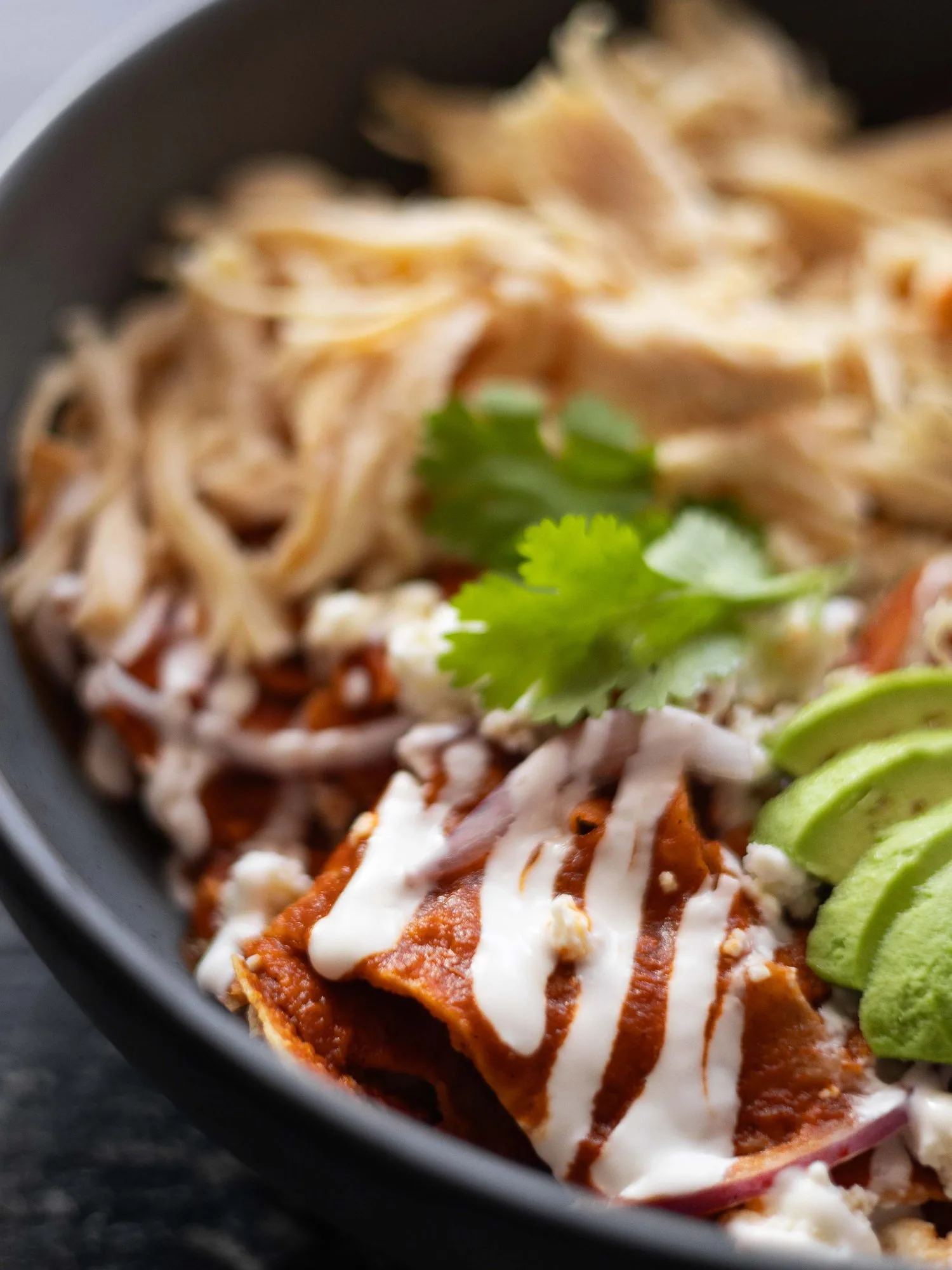Chilaquiles rojos con pollo, crema y aguacate