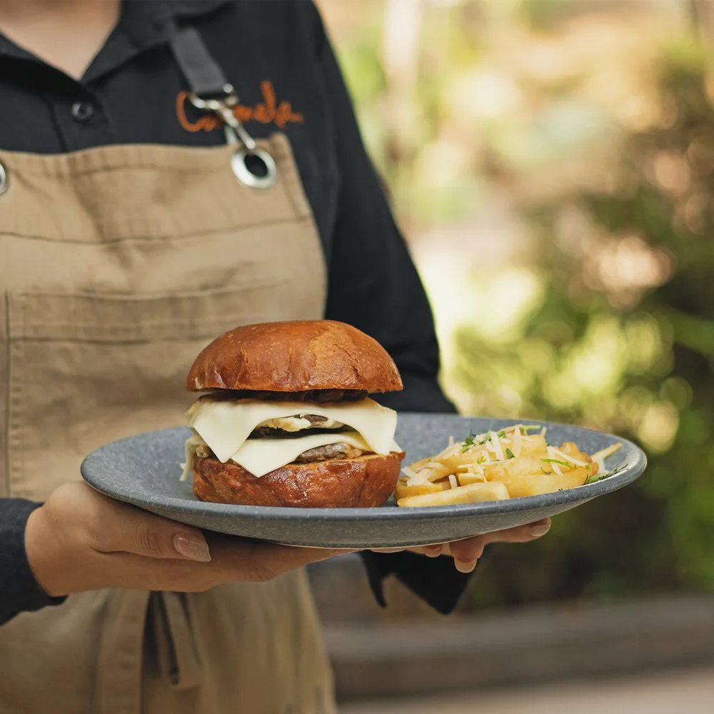 Mesera de Carmela con una hamburguesa y papas